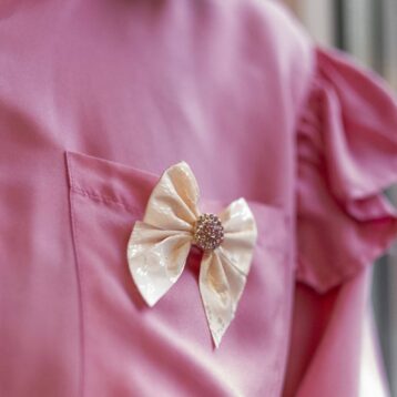 ByTiMo sin designsløyfe festet på en rosa bluse
