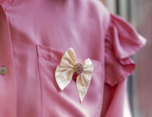 ByTiMo sin designsløyfe festet på en rosa bluse