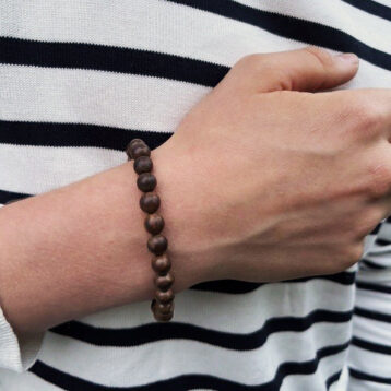 Stilrent armbånd i treperler på håndledd, håndlaget smykke i naturlige bruntoner